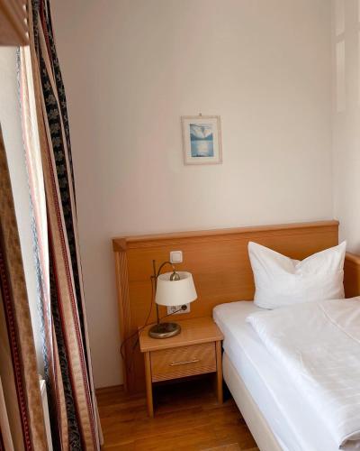 a bedroom with a bed and a lamp on a nightstand at Schwarzacher Hof in Niederbayern in Schwarzach