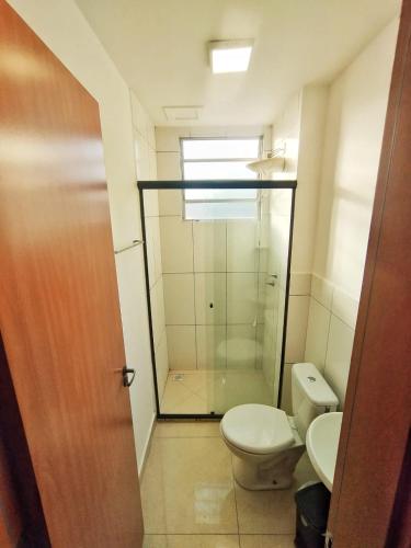 a bathroom with a toilet and a glass shower at Apartamento completo em Pinda in Pindamonhangaba
