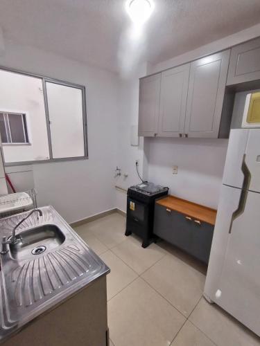 a kitchen with a sink and a stove in it at Apartamento completo em Pinda in Pindamonhangaba