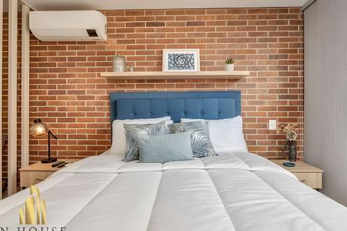 a bedroom with a large white bed with a brick wall at Kyux 405 - The Icon of Exclusivity in Laureles in Alpujarra