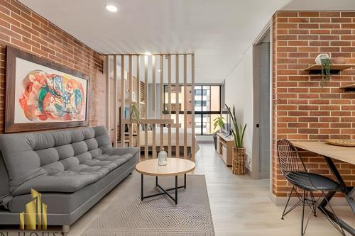 a living room with a couch and a brick wall at Kyux 405 - The Icon of Exclusivity in Laureles in Alpujarra