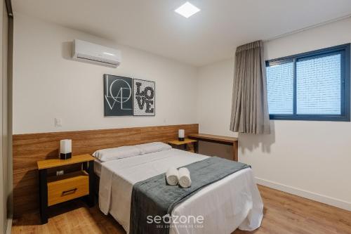 a bedroom with a bed with two shoes on it at Prédio c/ Aptos Novos a 300m da Praia - EEP in Guarapari