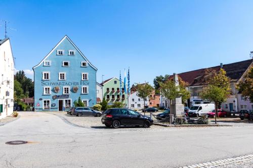 a car parked in a parking lot next to a blue building at Schwarzacher Hof in Niederbayern in Schwarzach