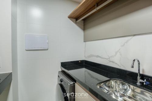 a kitchen with a sink and a stove at Prédio c/ Aptos Novos a 300m da Praia - EEP in Guarapari