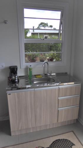 a kitchen with a sink and a window at Villa Holística in Nova Petrópolis
