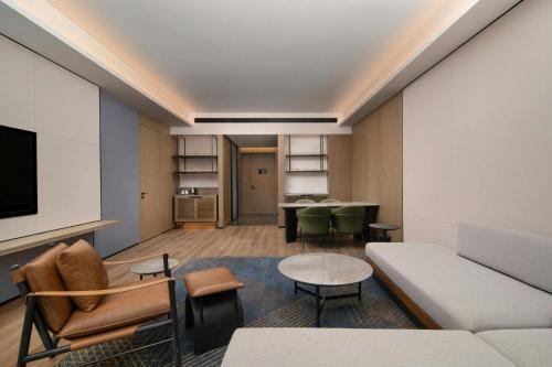 a living room with a couch and a table at Four Points by Sheraton Dalian Donggang in Dalian