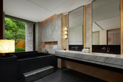 une salle de bain avec deux lavabos et un grand miroir dans l'établissement Grand New Century Resort, Changxing, A Tribute Portfolio Resort, à Guzhu