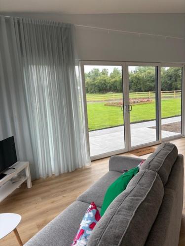a living room with a couch and a large window at Kildare Holiday Apartments No 1 in Kildare