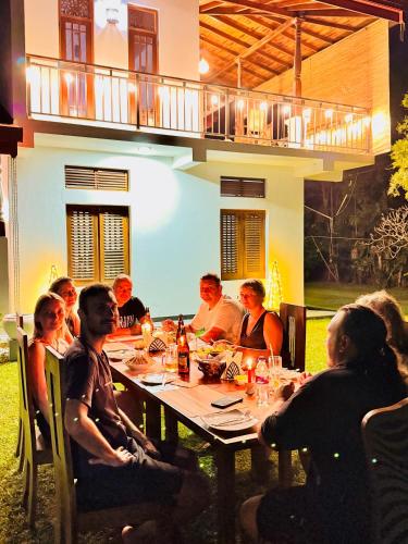 a group of people sitting around a dinner table at Villa 252 Kosgoda in Kosgoda