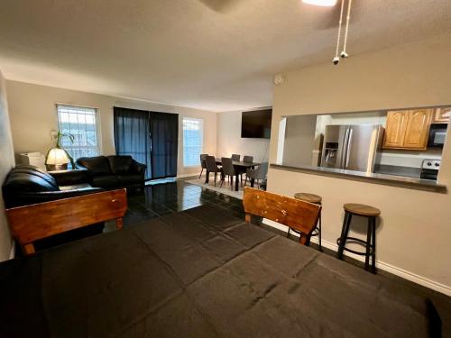 a living room and kitchen with a couch and a table at By Popular Demand - Houston in Houston