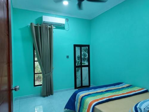 a blue room with a bed and a window at Zmz Homestay in Pasir Mas