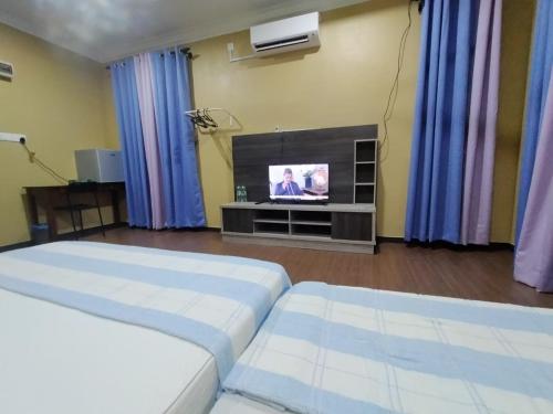 a living room with two beds and a television at Zmz Homestay in Pasir Mas