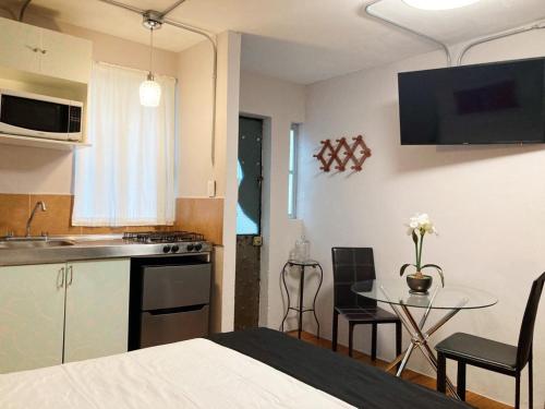 a kitchen with a sink and a table in a room at Suites Viveros Coyoacán I Hospedaje a tu medida in Mexico City