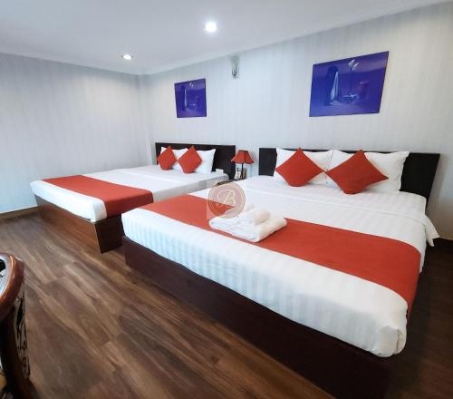 a hotel room with two beds with red and white sheets at Beautiful Hotel Bui vien in Ho Chi Minh City