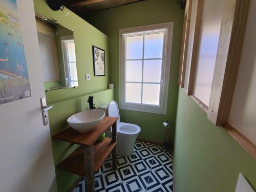 a bathroom with a sink and a toilet and a window at Gîte de l'Aiguille in Civray-de-Touraine