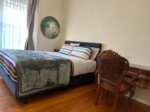 a bedroom with a bed with a chair and a desk at One Bedroom Villa Spacious Room,Amazing Location All Perks in Auckland