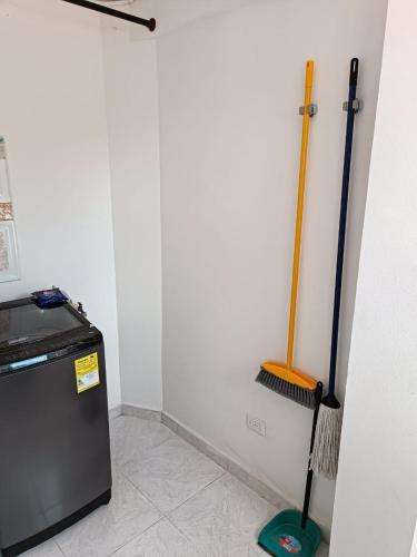 a room with a broom next to a refrigerator at La Estrella 2 in Dosquebradas