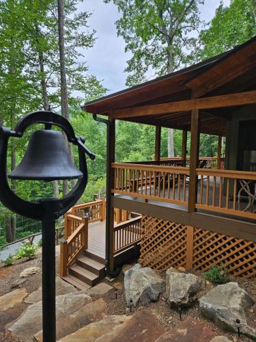a large deck with a bell next to a cabin at Bungalow, Lake Glenville, Amazing Views, & Sauna! in Cullowhee