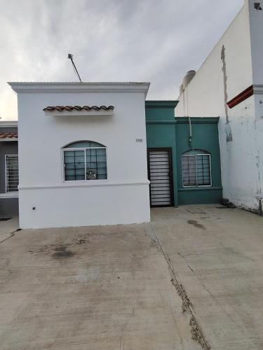 a white and green building with a window at Casa vacacional in Mazatlán