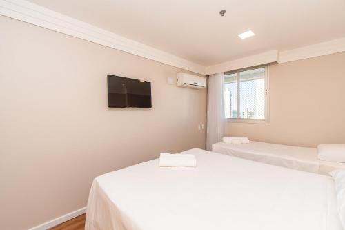 two beds in a room with a tv on the wall at BSB STAY Torre Flats Particulares - Mercure Líder in Brasilia