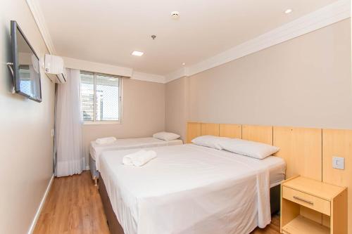 a room with two beds and a television in it at BSB STAY Torre Flats Particulares - Mercure Líder in Brasilia