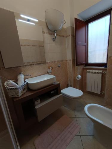 a bathroom with a sink and a toilet and a mirror at CasaNorah in Fondi