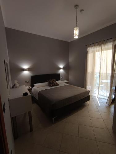 a bedroom with a bed and a table and a window at CasaNorah in Fondi