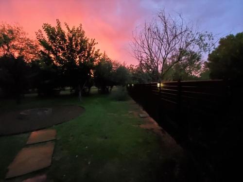 a fence in a yard with a sunset at Verde Valley Ranch Retreat - 4BR Guest House by Sedona & Jerome in Cottonwood