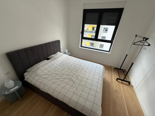 a small bedroom with a bed with a window at M&A apartman in Trebinje