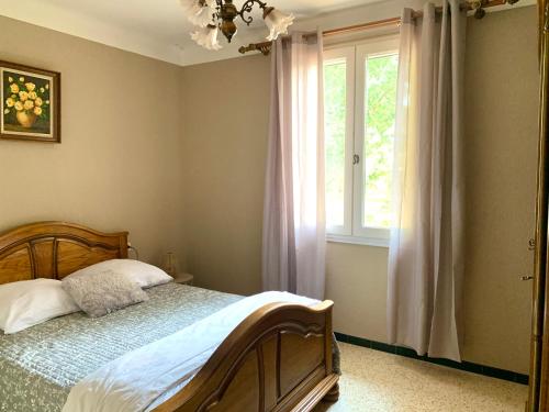 a bedroom with a bed and a window at La maison aux oiseaux - Luberon in Oppède