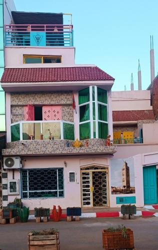 a pink building with lots of windows on top of it at Riad SULTANA lateral seaview in Saidia 