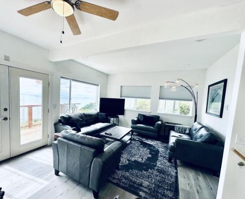 a living room with couches and a ceiling fan at Paradise Suites Eagles Nest in Homer