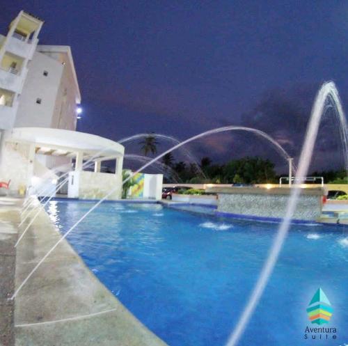 a pool with water fountains in front of a building at Hotel Aventura suite in Boca de Aroa
