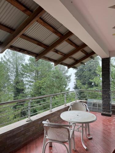 a patio with two chairs and a table on a balcony at 1-Bedroom Cozy Private Stay In Changla Gali in Chhāngla Gali