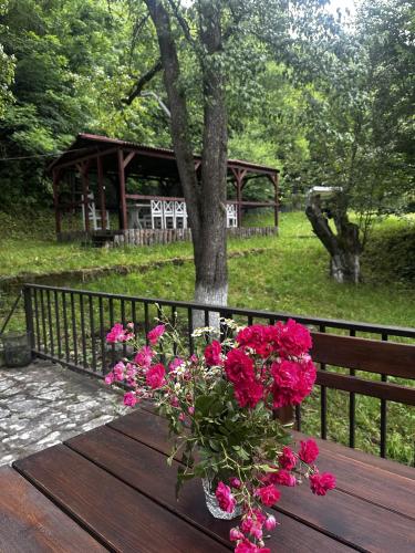 a wooden table with pink flowers on a fence at Noor Dilijan in Dilijan