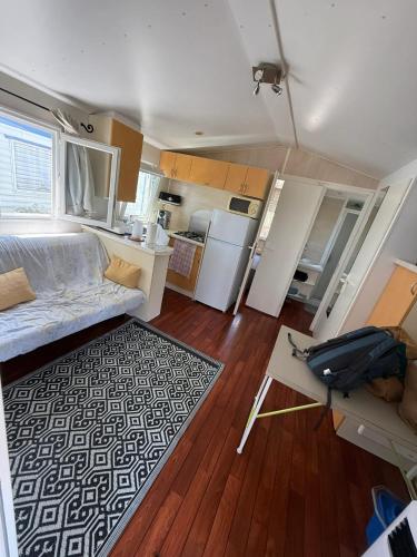 un salon avec un canapé et une cuisine dans l'établissement Bungalow tranquille à Marseillan avec terrasse 32 m², à Marseillan