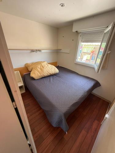 une petite chambre avec un lit et une fenêtre dans l'établissement Bungalow tranquille à Marseillan avec terrasse 32 m², à Marseillan