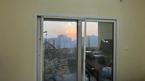 a window in a room with a view of a city at AlNahda Border SHJ-DXB -ZAMAZM GuestHouse in Sharjah
