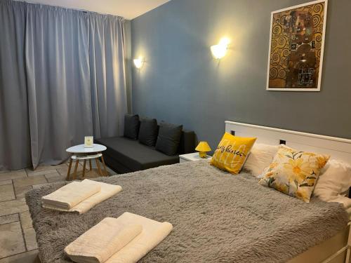 a bedroom with a bed with pillows and a couch at Kaliakria Vibes studio apartment in Topola