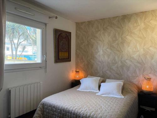 - une chambre avec un lit avec deux oreillers et une fenêtre dans l'établissement Résidence Les Roches Blanches - Appartement vue mer terrasse et accès à la plage MAE-1101, à Trébeurden