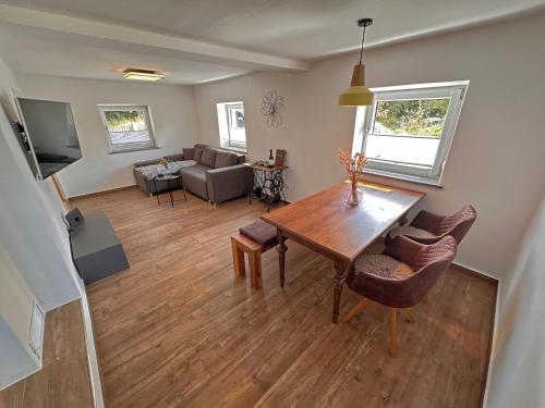 a living room with a table and a couch at Freistehendes Haus mit Ofen, Terrasse und Garten in Stadlern