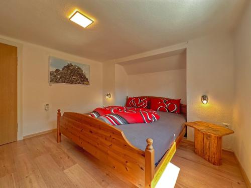 a bedroom with a wooden bed with red pillows at Freistehendes Haus mit Ofen, Terrasse und Garten in Stadlern