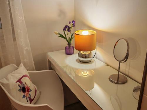 Un baño con una mesa con espejo y una lámpara. en Comfort Lovely Apartment Diva 2, Čiovo, Okrug, en Trogir