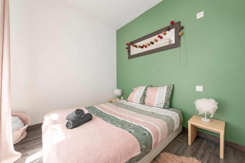 une chambre avec un lit et un mur végétal dans l'établissement Centre Ville -Cosy 2 pièces-Clim-AF, à Carcassonne