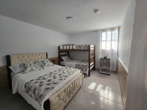 a bedroom with two beds and a bunk bed at Hotel Rodadero Dorado in Santa Marta