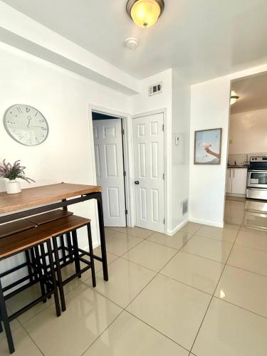 a kitchen with a table and a clock on the wall at Renzzi Villas in Miami
