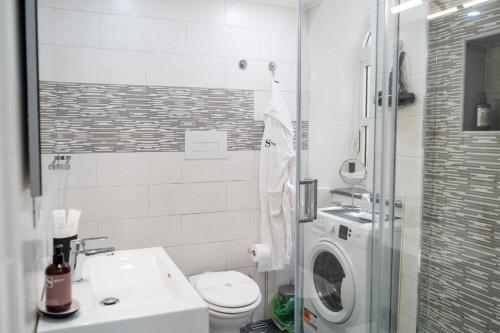 a bathroom with a sink and a washing machine at Scugnizzo Apartment SMART in Naples