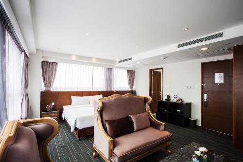a hotel room with a bed and a chair at Le Prabelle Hotel in Hong Kong