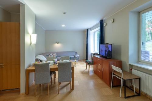 a dining room and living room with a table and chairs at Private Entry Apt Pärnu in Pärnu