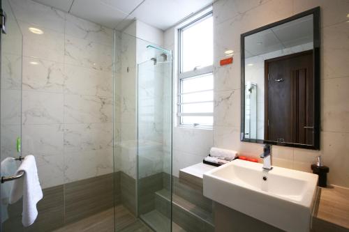a bathroom with a sink and a glass shower at Le Prabelle Hotel in Hong Kong